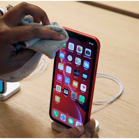 An employee cleans an iPhone Apple XR during the press visit of the new Apple Store Champs-Elysees on November 15, 2018 in Paris, France. Polishing costs at Apple cost $19, which is a common price point for their smaller accessories.