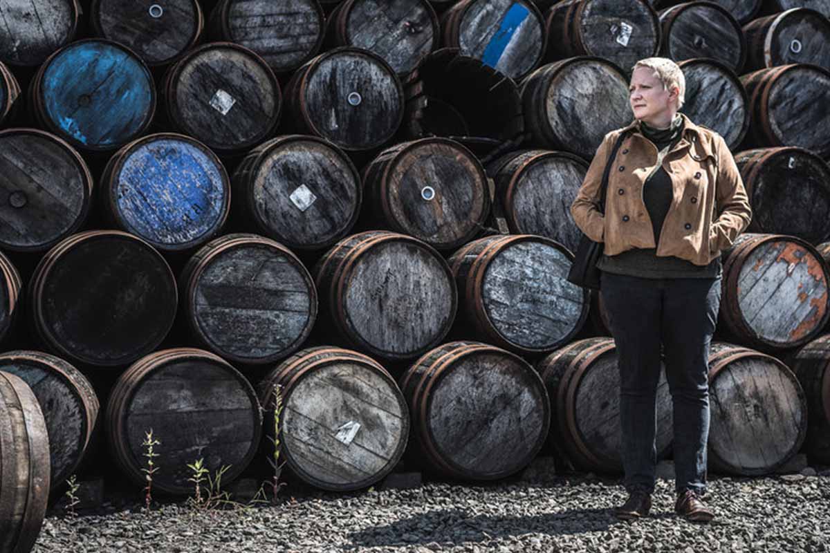 Dr. Emma Walker in front of barrels. Dr. Walker is the first Master Blender in Johnnie Walker's 201-year history