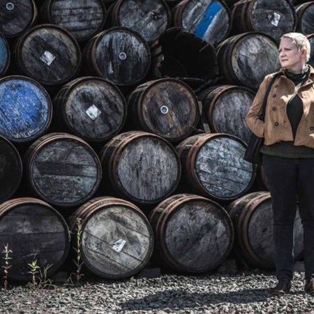 Dr. Emma Walker in front of barrels. Dr. Walker is the first Master Blender in Johnnie Walker's 201-year history