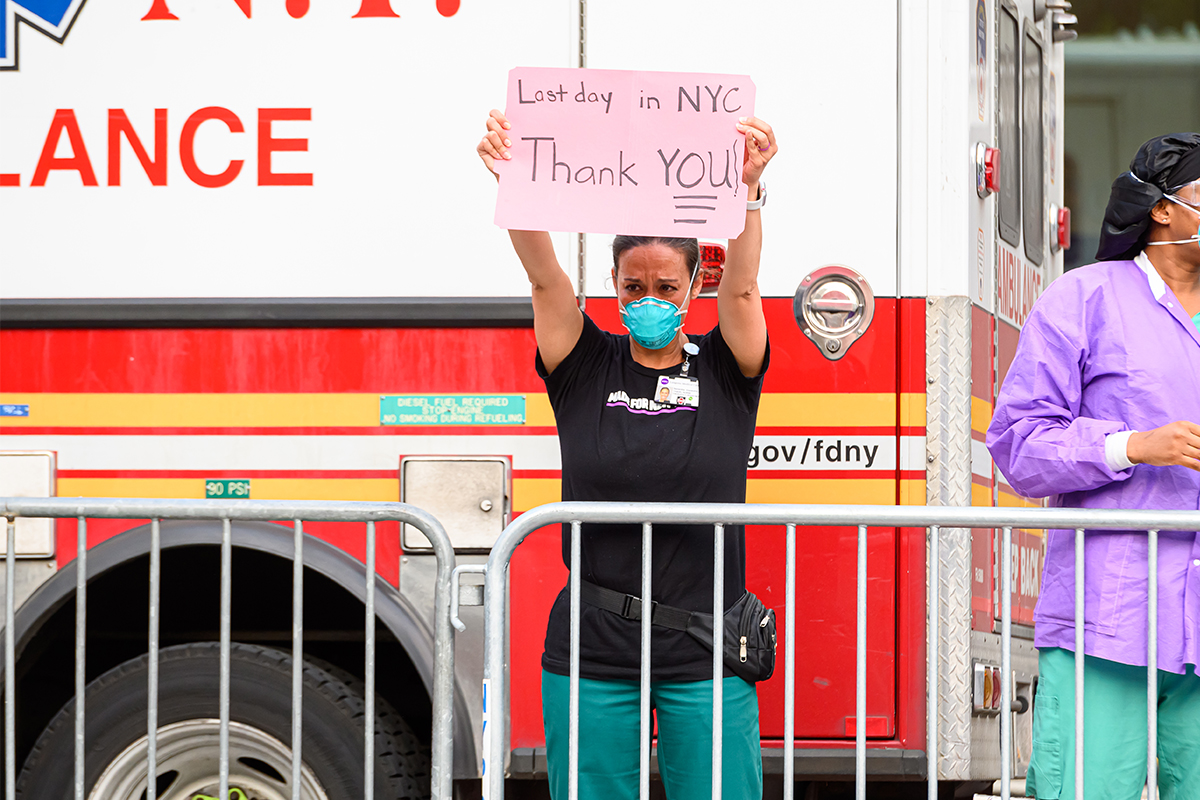 A frontline worker holds up a sign. Psychedelic treatment is being considered for COVID-related PTSD.