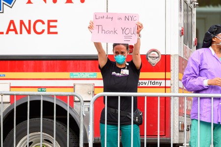 A frontline worker holds up a sign. Psychedelic treatment is being considered for COVID-related PTSD.