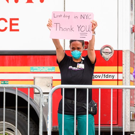 A frontline worker holds up a sign. Psychedelic treatment is being considered for COVID-related PTSD.