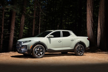 The 2022 Hyundai Santa Cruz, a new small pickup truck for the American market, sitting in an illuminated spot in the middle of a forest