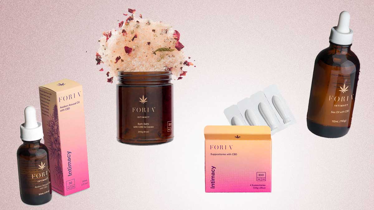 A couple lying on a blanket with Foria products.