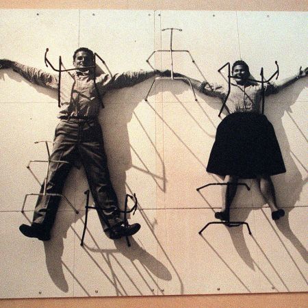 A photo mural of designers Charles and Ray Eames