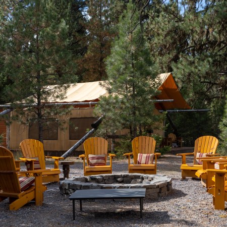 adirondack chairs around a firepit in one of the camps at the resort at paws up in montana