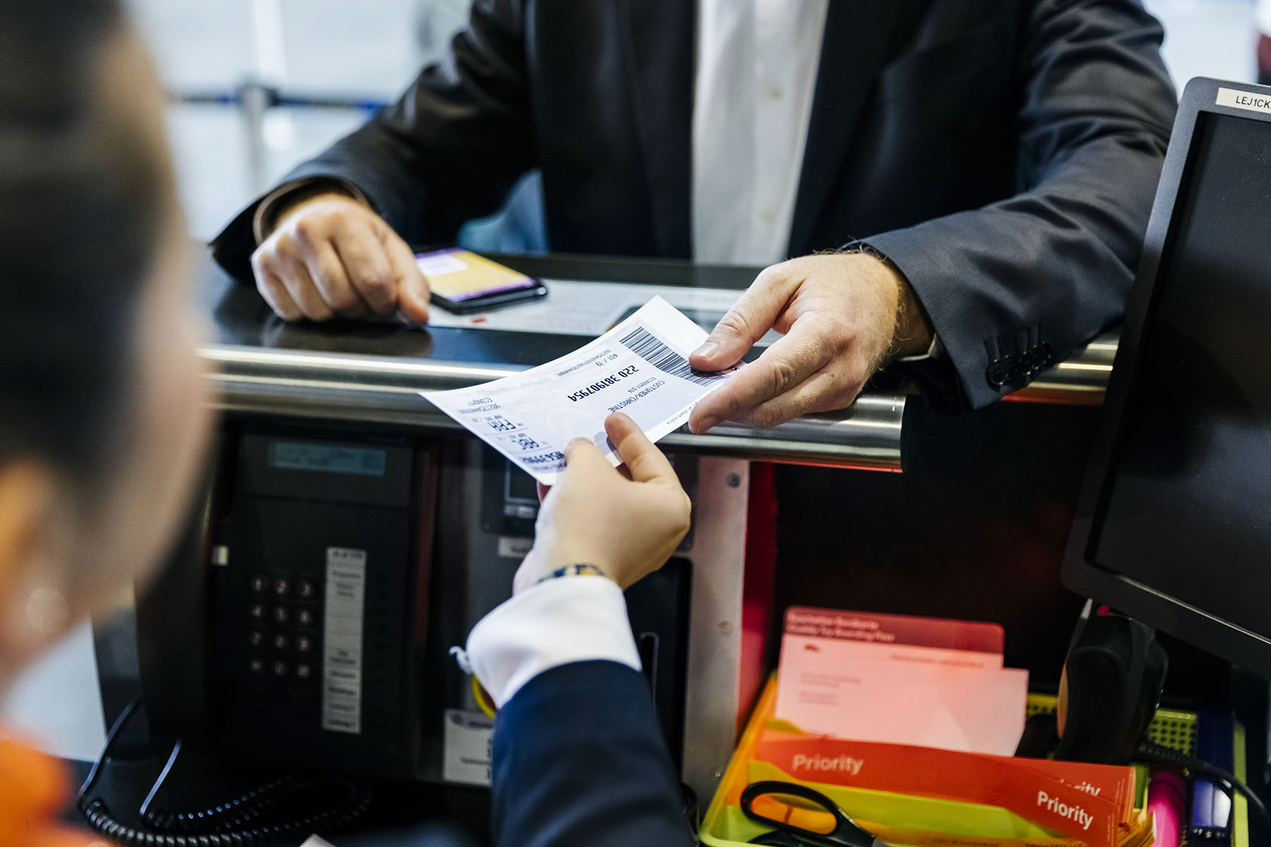 an airline passenger hands a ticket to a gate agent