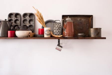 A kitchen shelf with cookware, bakeware and other cooking needs