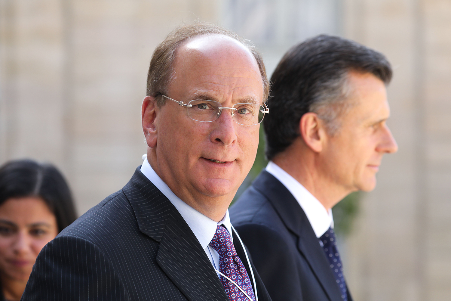 BlackRock CEO Larry Fink leaves a meeting with French President Emmanuel Macron in 2019. In his 2022 CEO letter, Fink argues for sustainable investing.