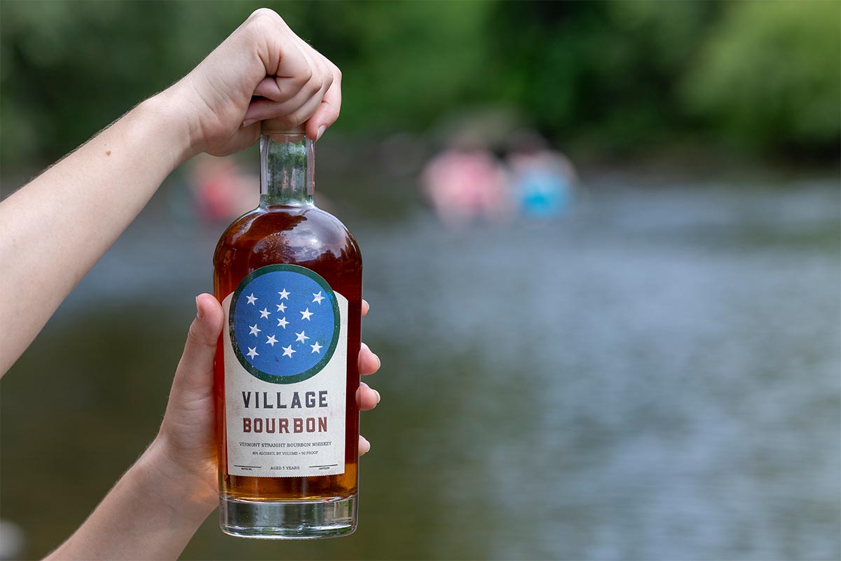 Village Bourbon bottle being opened outside