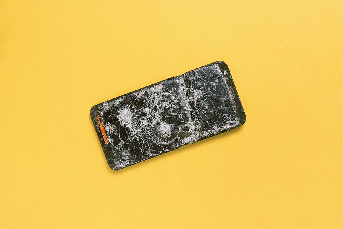 A photo of a cracked phone against a yellow background. Here's what it was like when I went on a 72-hour digital detox from my phone.