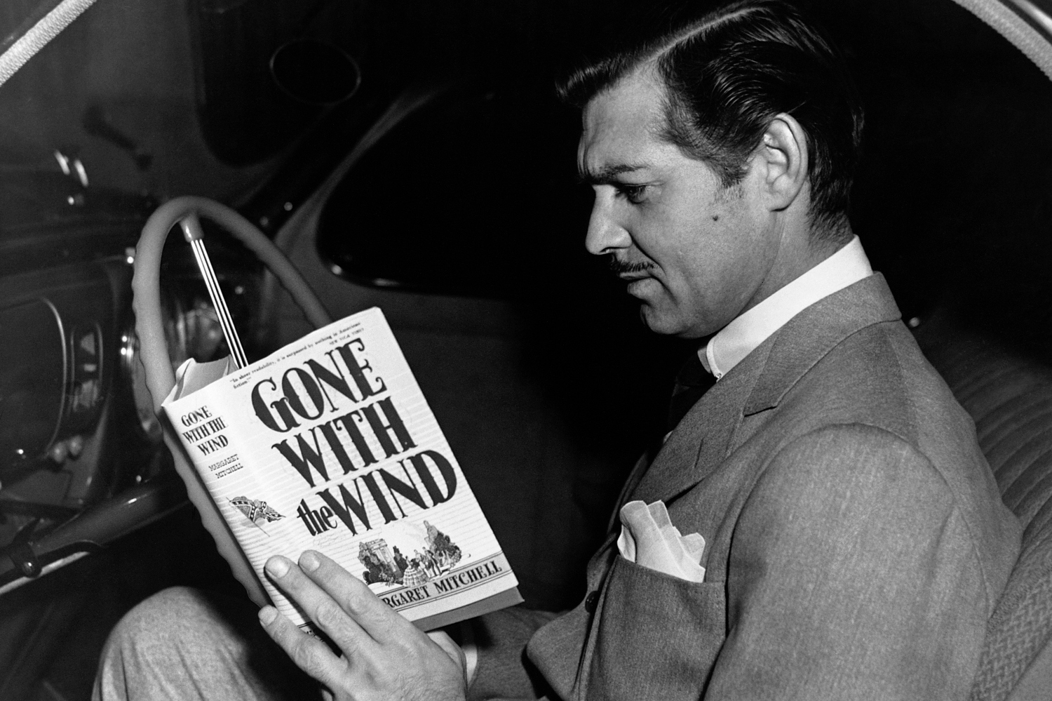 The actor Clark Gable, who played Rhett Butler in the 1939 film Gone with the Wind, reads a copy of the novel by Margaret Mitchell on which the film was based.