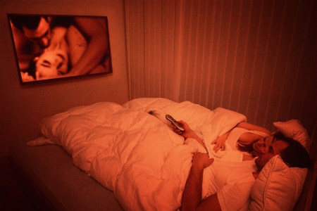 A couple lying in bed watching porn together