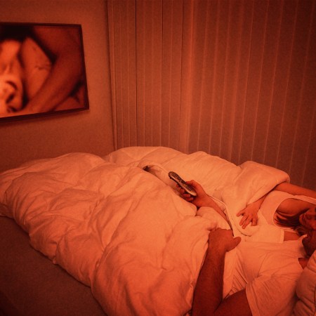 A couple lying in bed watching porn together
