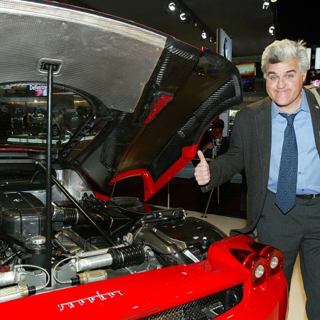 Jay Leno checks out the Ferrari Enzo engine at the North American International Auto Show in Detroit, Michigan on January 5, 2003. In 2021, Leno explained why he doesn’t own a Ferrari.