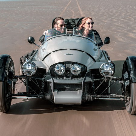 The new Super 3, from England's Morgan Motor Company. The three-wheeler is seen here with two passengers being driven on the sand.