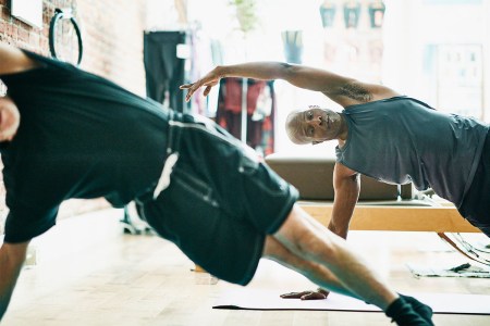 Two men performing a side plank in a class. You know what exercise is even better? The Copenhagen plank.