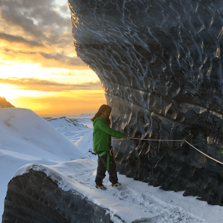 A woman hiking on a glacier in Iceland. We put together an itinerary for those looking to visit Iceland in the off-season.