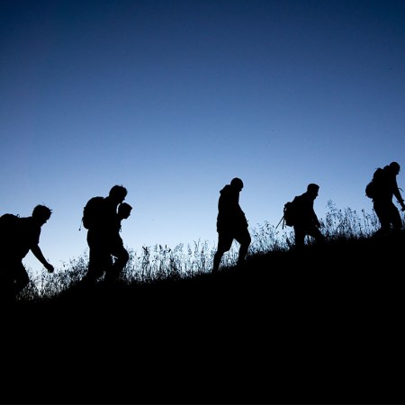 A group of men walking with rucksacks.