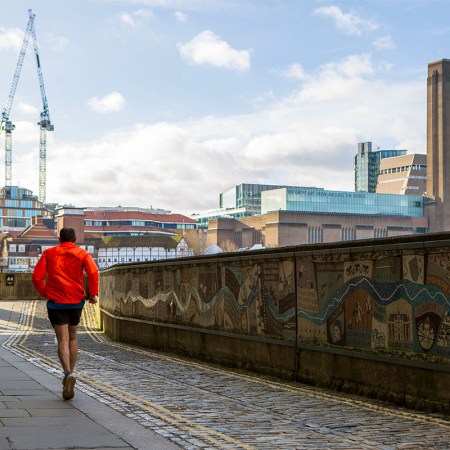 A man runs along a canal in London. If you're having trouble making time for workouts during the week, consider "exercise snacking."