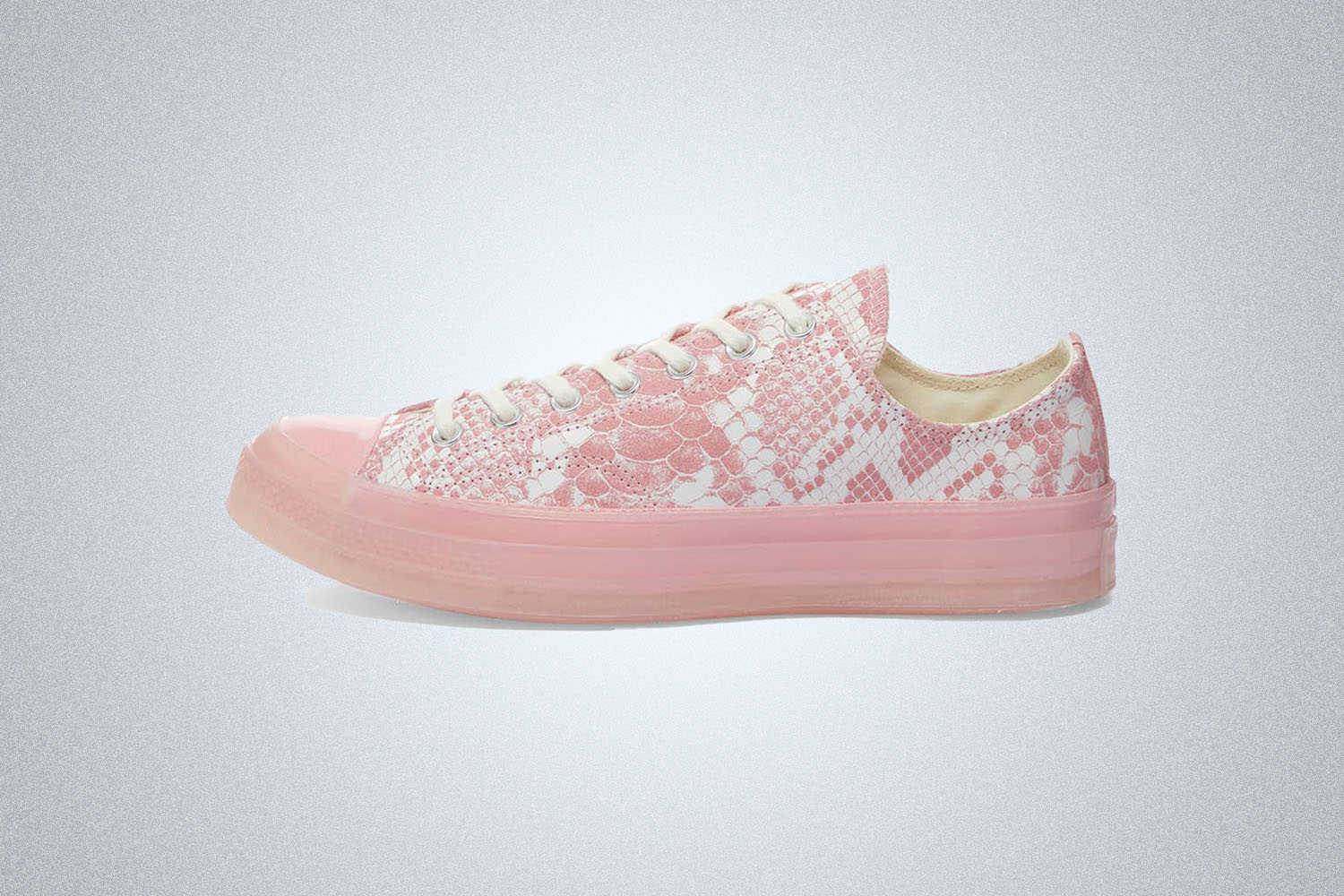 a pink, snakeskin Converse sneaker on a grey background