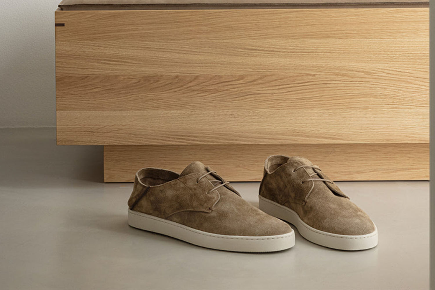 Two sneakers in front of a wooden block