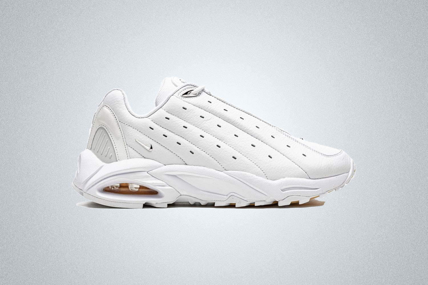 a pair of white Nike '90s-inspired sneakers on a grey background