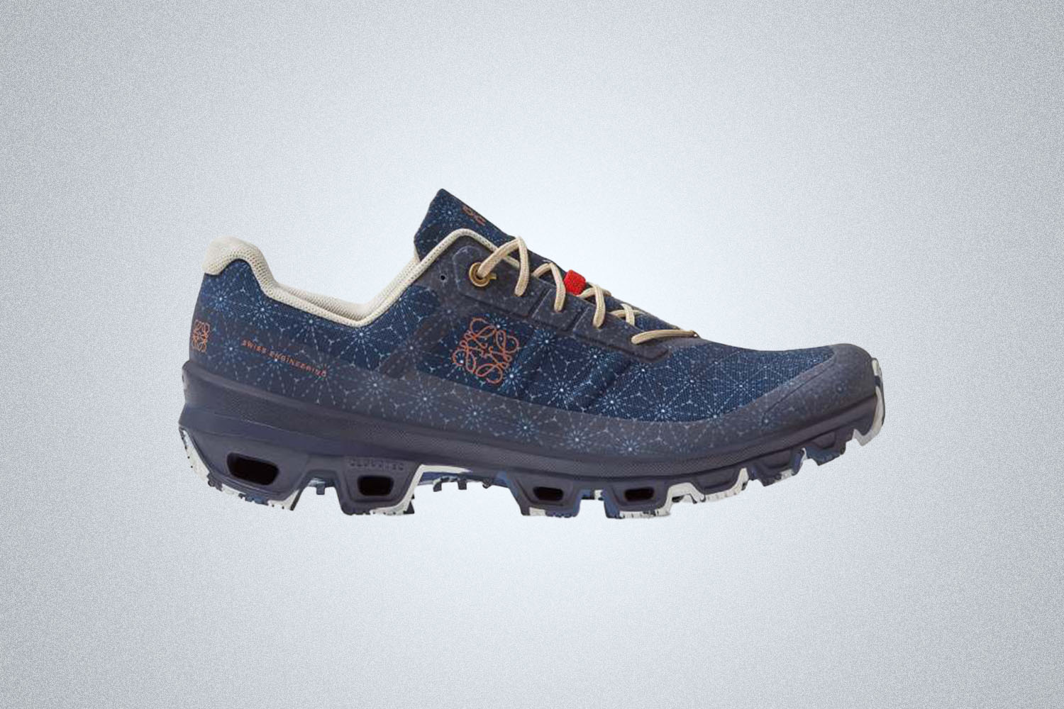 a blue, grey and galaxy-patterned trail shoe from On Running on a grey background