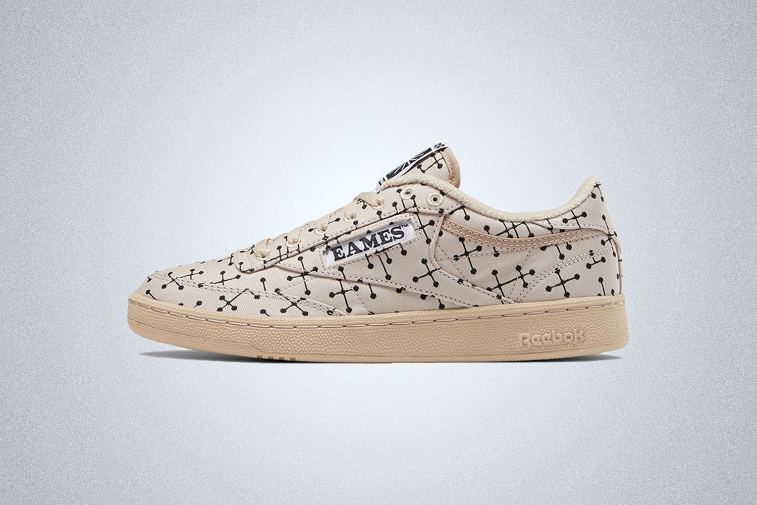 a beige Reebok sneaker with point-dot pattern on a grey background