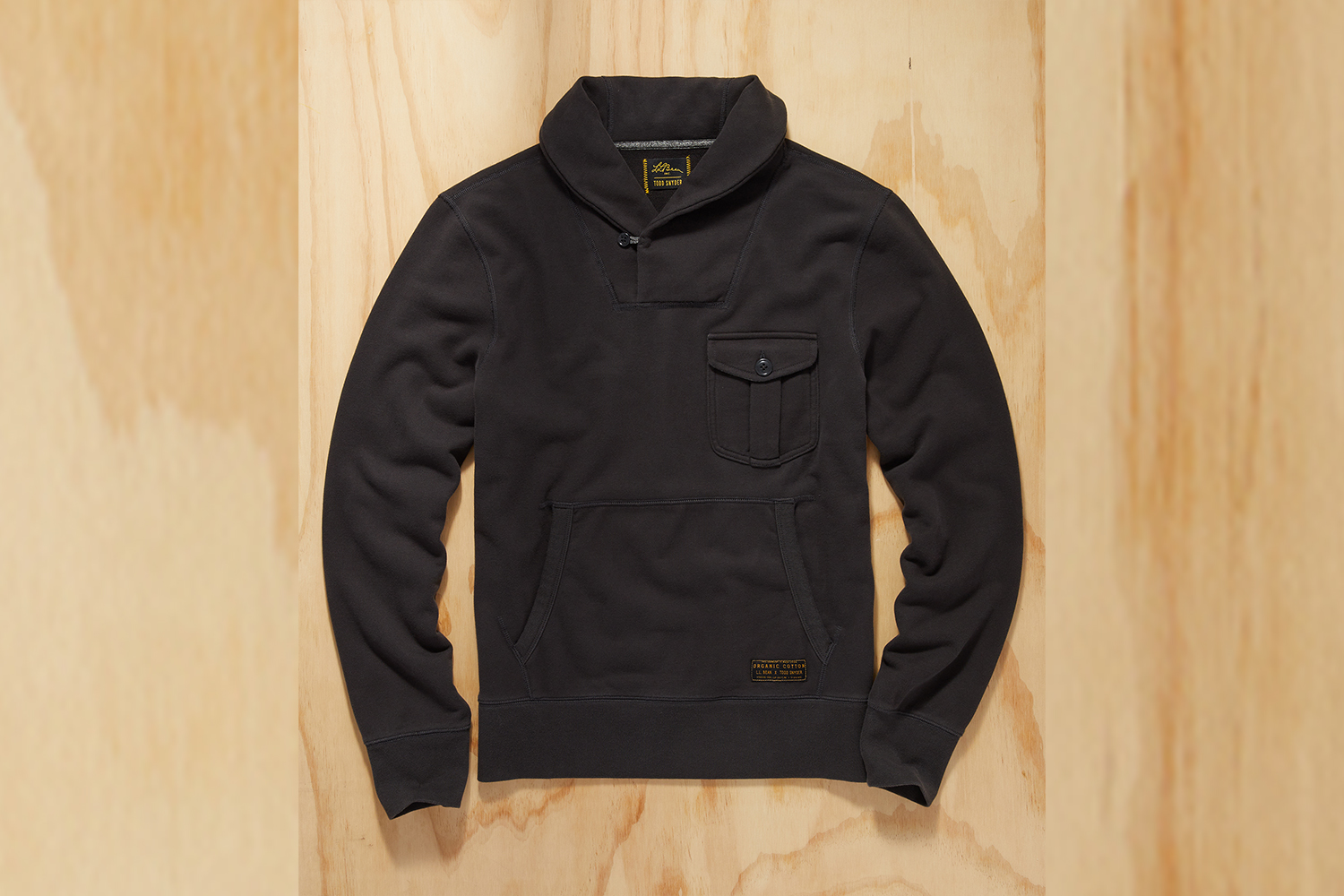 a black shawl neck sweater on a wood background