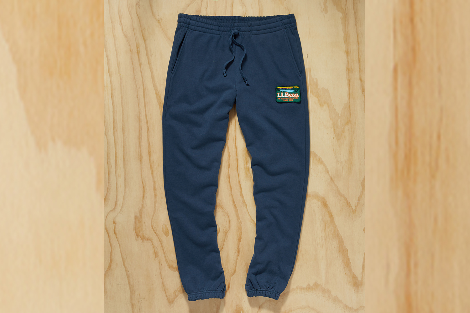 a pair of blue sweatpants on a wood background