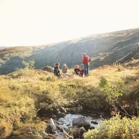 A family camping in nature. We take a look at Steven Rinella's parenting philosophy he calls "radical engagement."