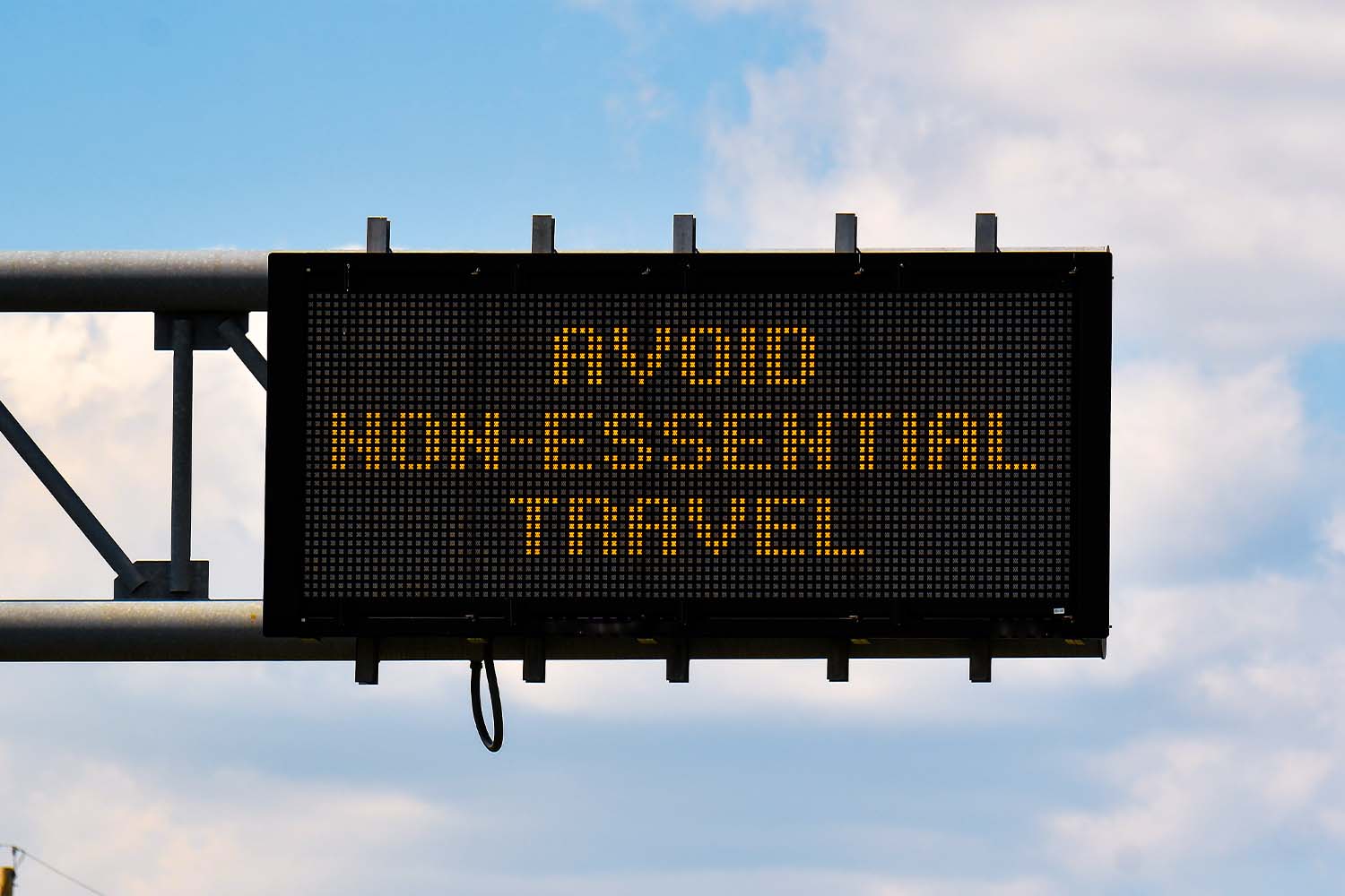A sign above a road reading "Avoid Non-Essential Travel"
