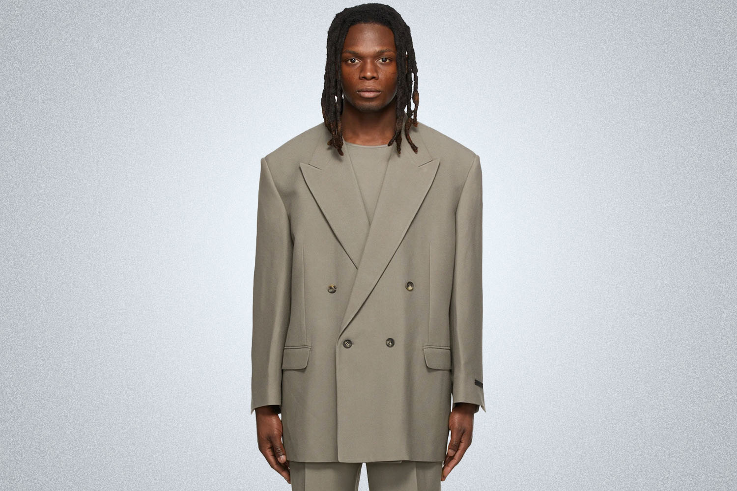 a model in a grey FOG double-breasted blazer on a grey background