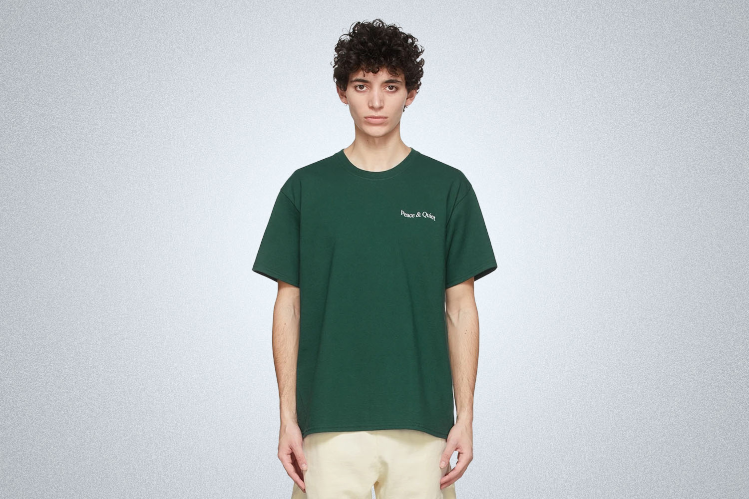 A model in a green MOPAQ tee on a grey background