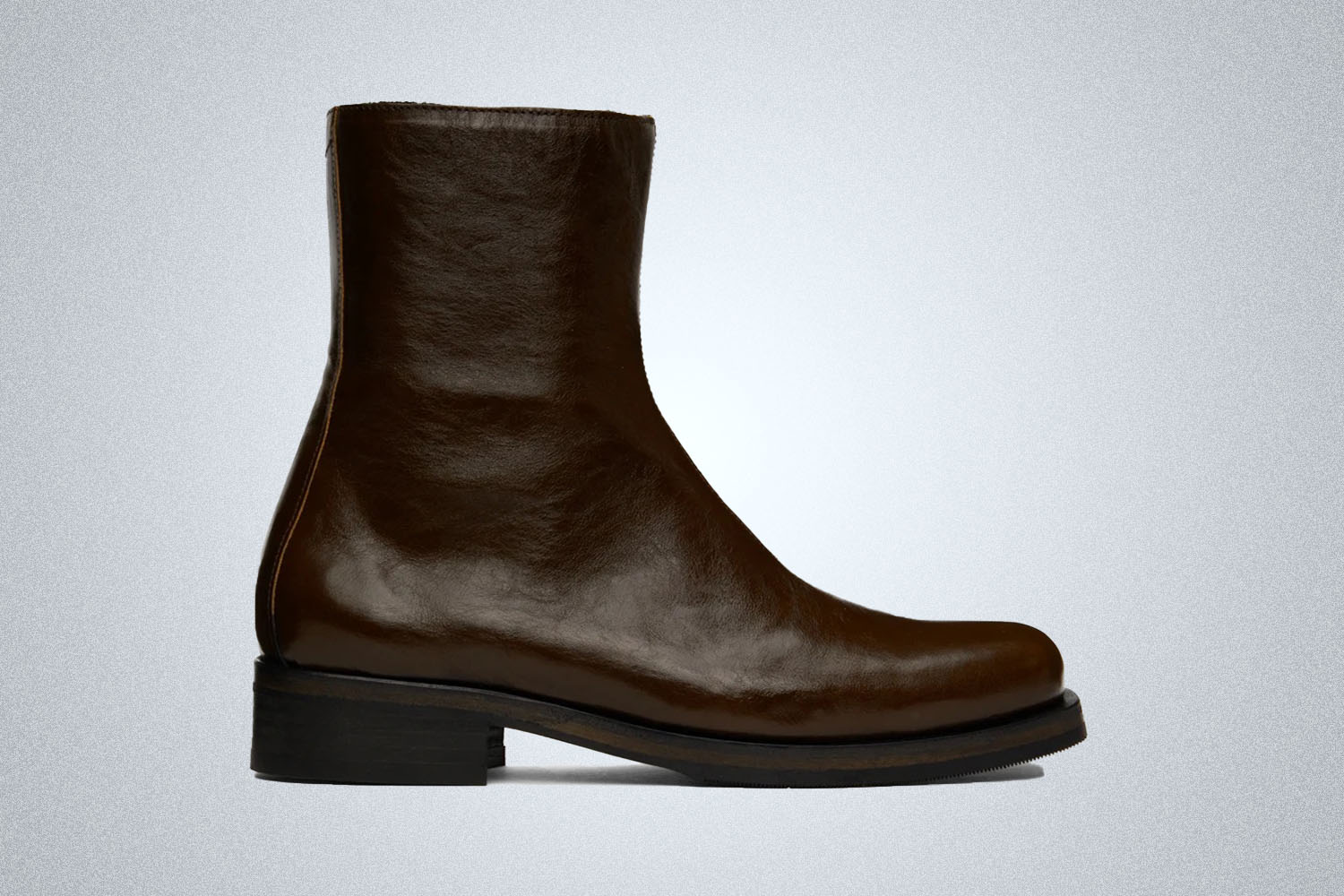 a brown elather bloot with black heeled sole from Our Legacy on a grey background