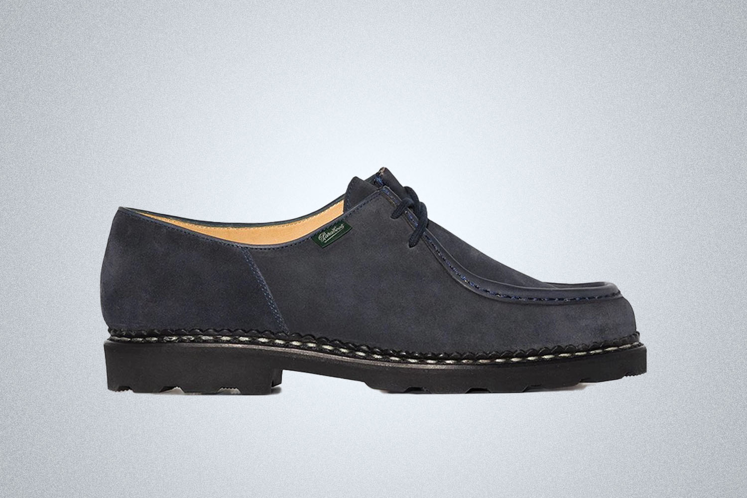 A black lace up shoe from Paraboot on a grey background