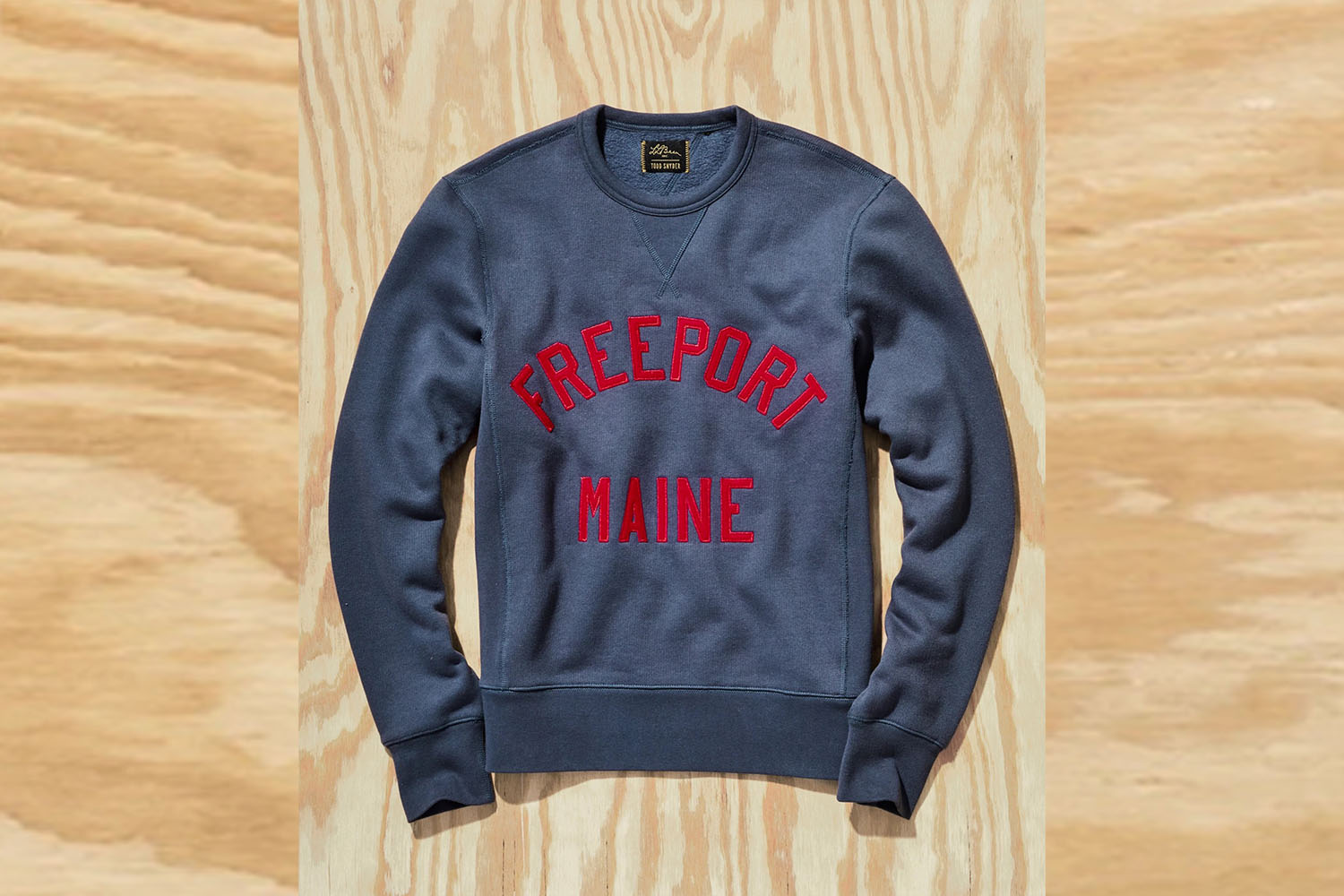 a Todd Snyder x L.L. Bean Crewneck on a wooden background