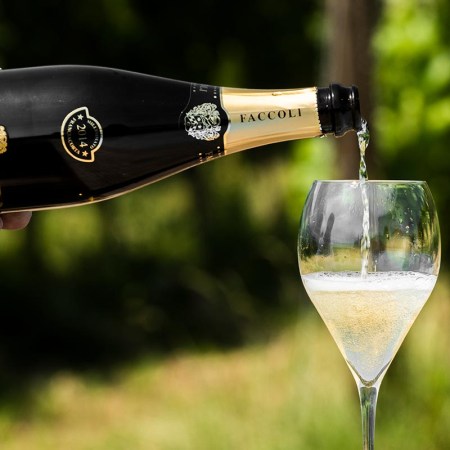 A bottle of Faccoli Franciacorta Brut NV poured into a glass