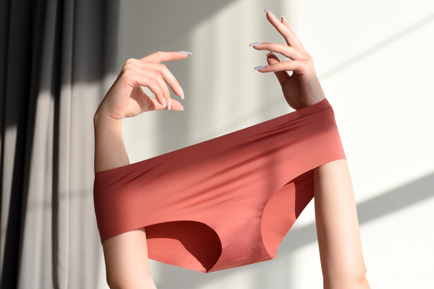 A woman holds a pair of seamless panties above her head