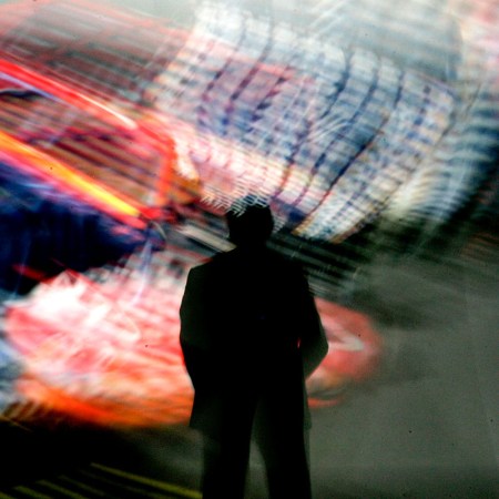 A man staring at a blur of color on the wall.