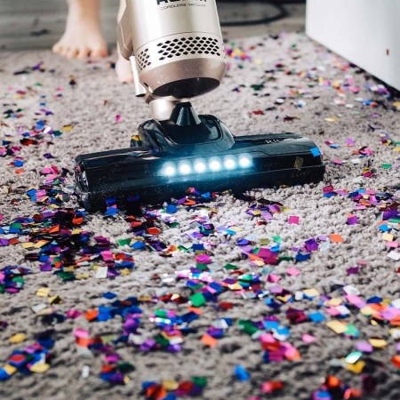 Remnants of a party being vacuumed up, including multicolored glitter strewn across the floor