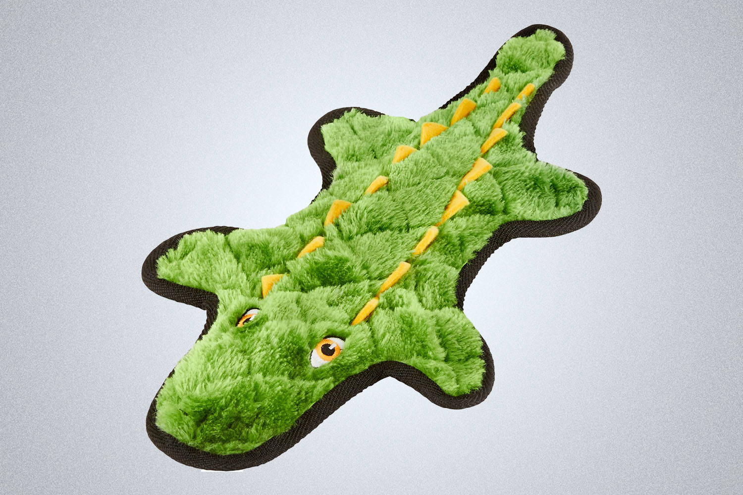 a fuzzy alligator dog chew toy from brand Frisco on a grey background
