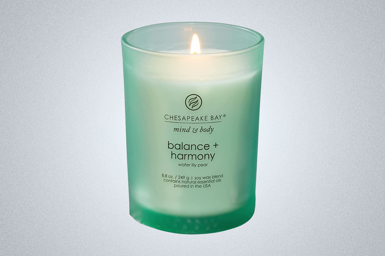 A scented candle in a green jar from Amazon on a grey background