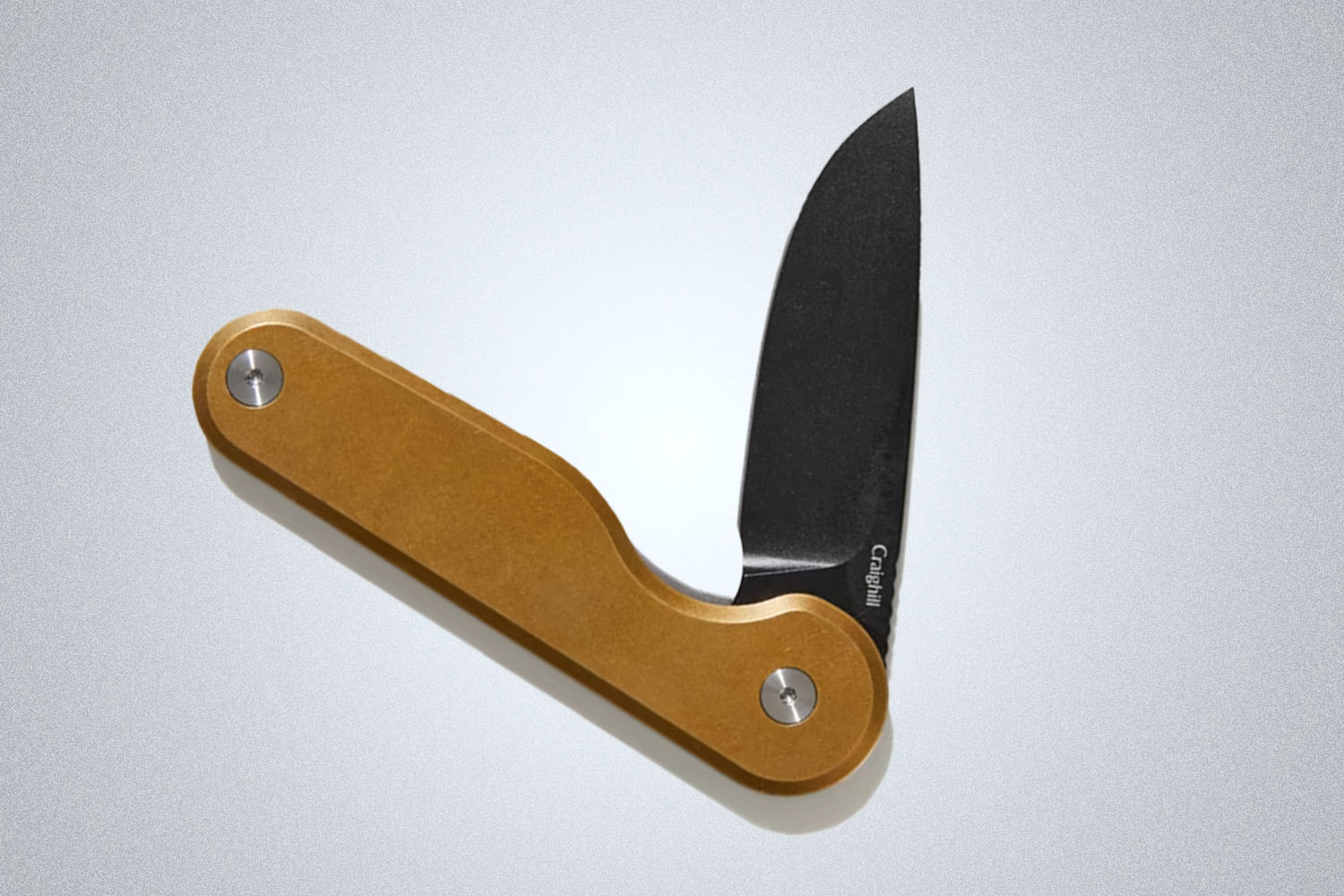 A Craighill brown-hilted knife with a black blade from Bespoke Post on a grey background