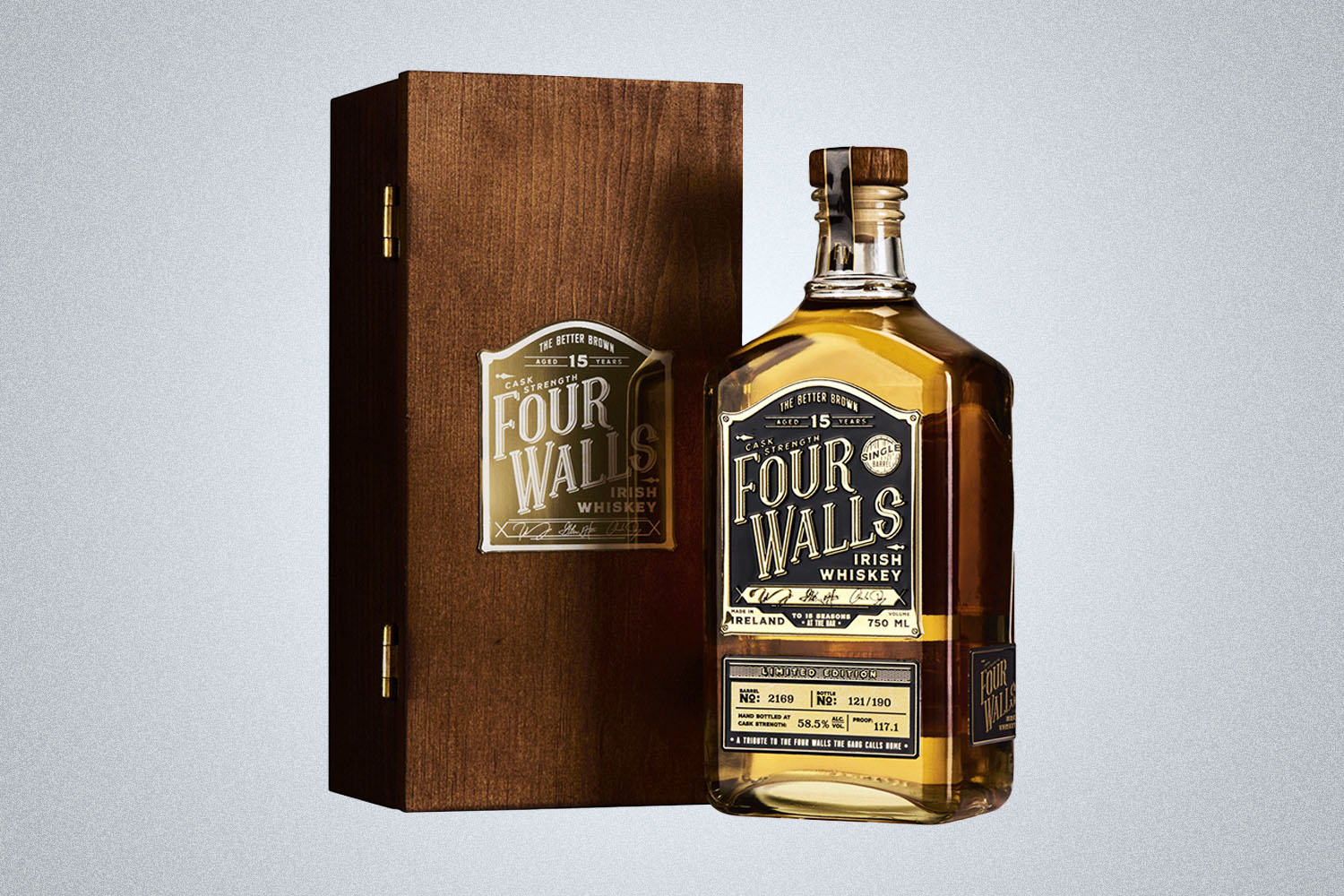 a bottle of whiskey and it's case on a grey background