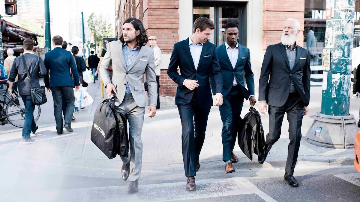 A group of men in Indochino suits walking down the street