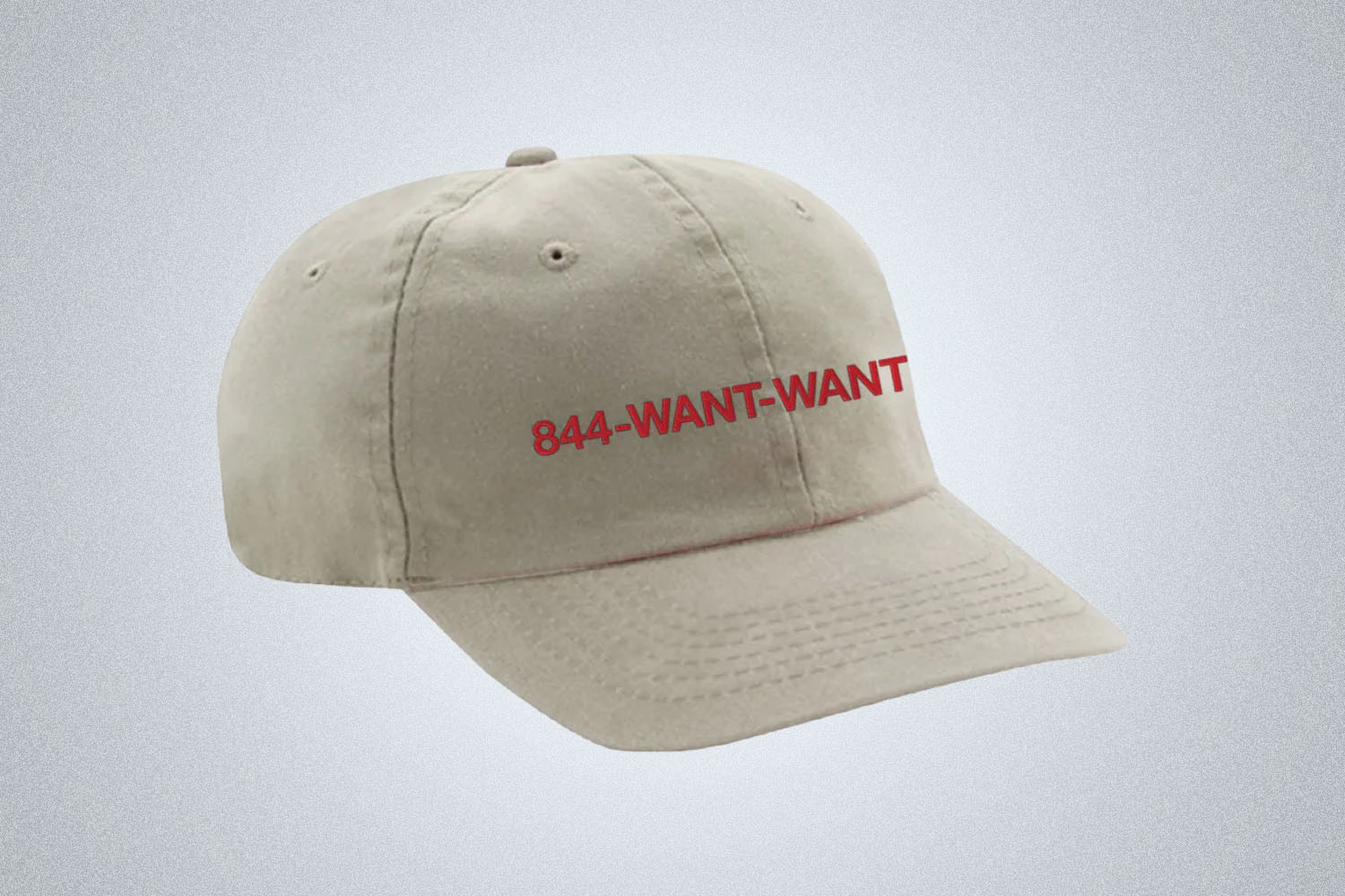 a biege hat with embroidery on a grey background
