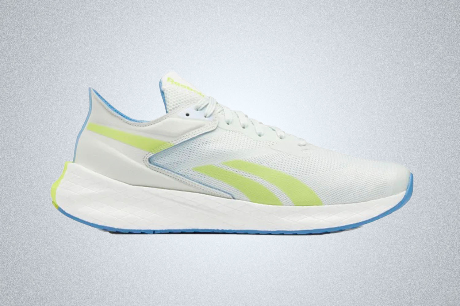 A pair of white and green accented Reebok running shoes on a grey background