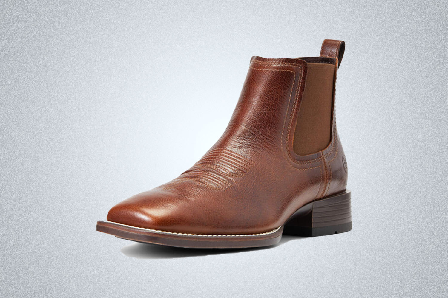 a western style lowcut leather boot from Ariat on a grey background